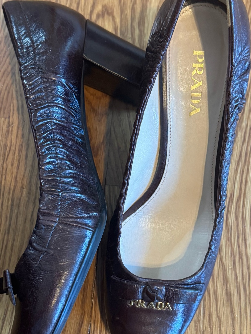 Size 9 Prada Dark Brown Leather Block Heel Pumps with bow and logo detail.